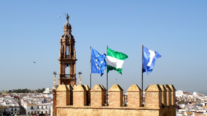 View of the church steeple, with the flags of the European Union, of Andalucía, and of Carmona.
